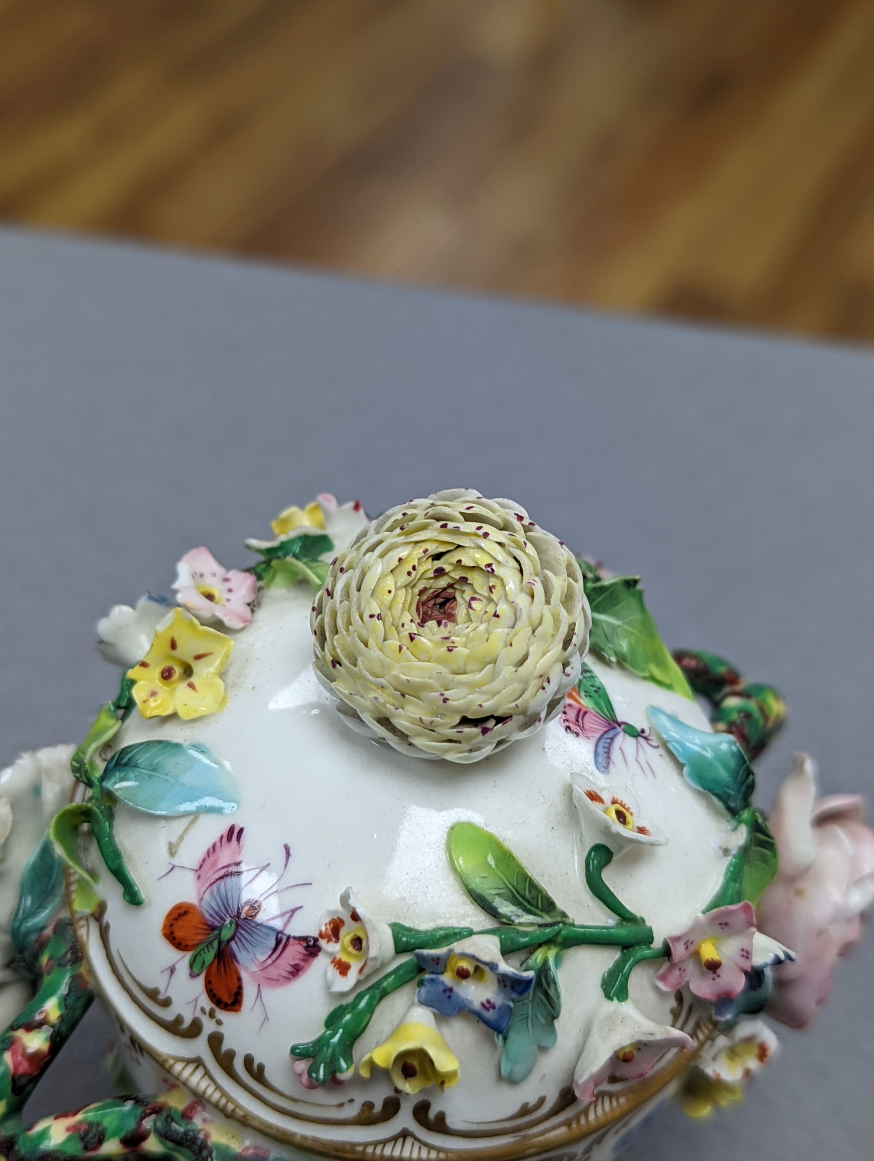 An 18th century Mennecy porcelain cup and cover, a Meissen style cup and cover, an English porcelain floral encrusted double inkwell and cover and a similar jar and cover